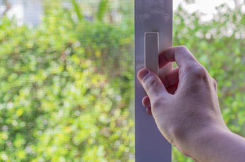 Ein Mann schließt ein Fenster