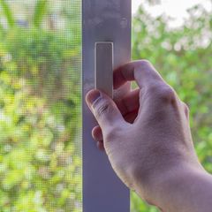 Ein Mann schließt ein Fenster