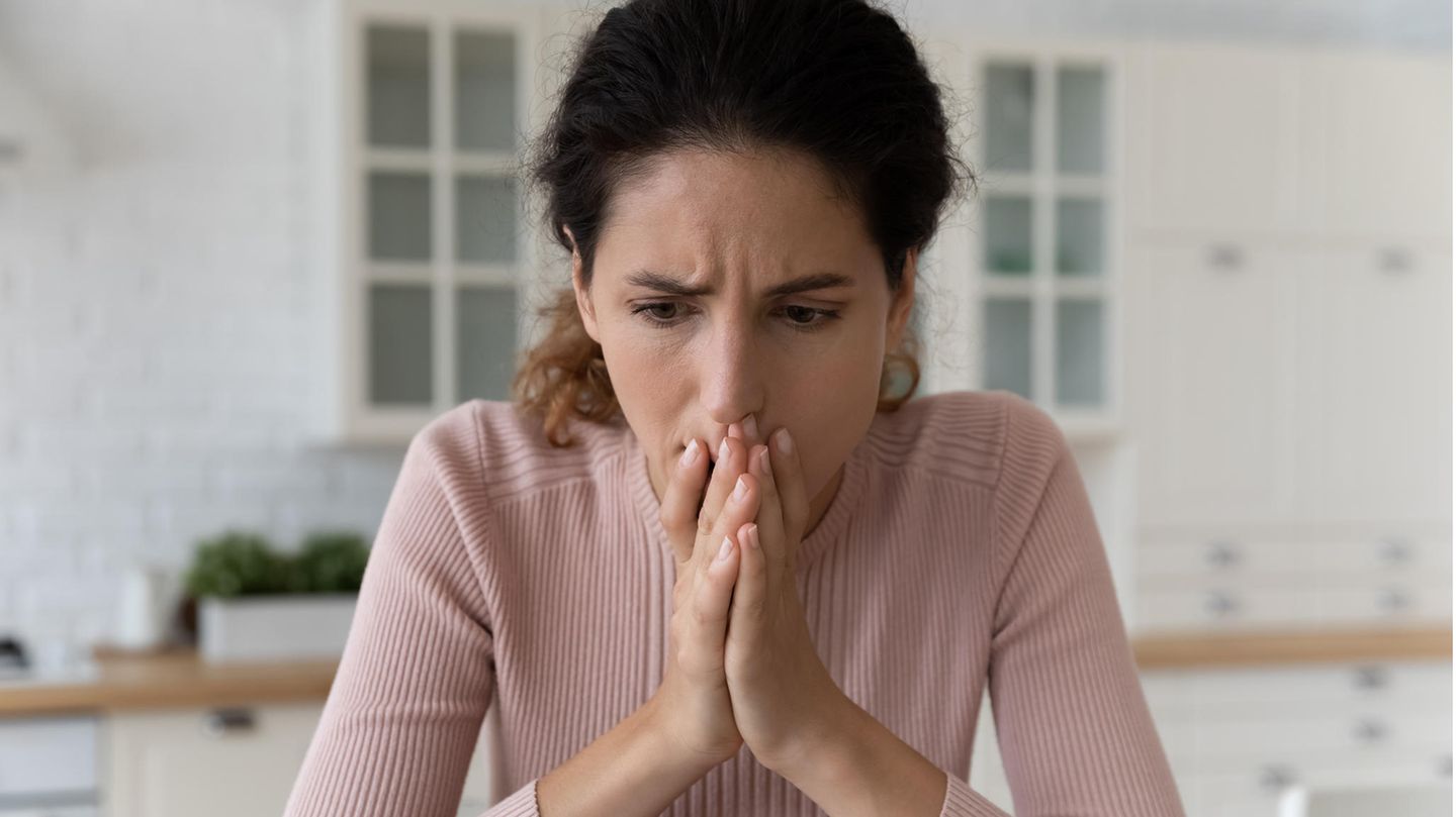 Eine Frau schaut schockiert auf Ihren Bildschirm