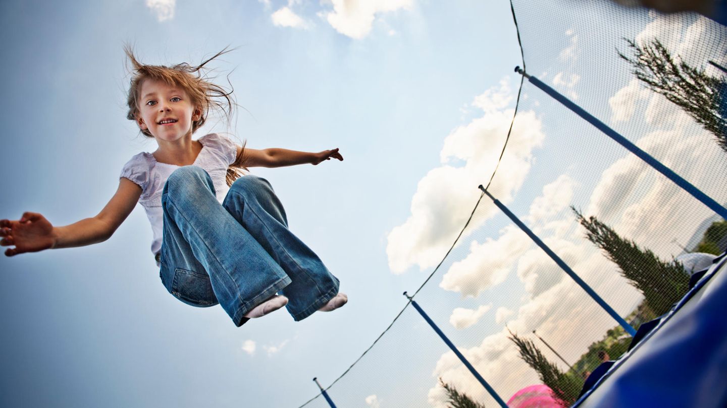 Ein kleines Mädchen springt auf einem Trampolin