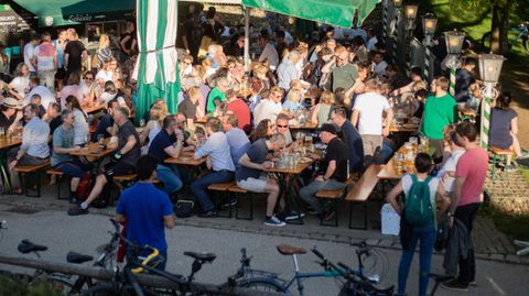 Bei sonnigem Wetter sitzen Menschen in München in einem Biergarten