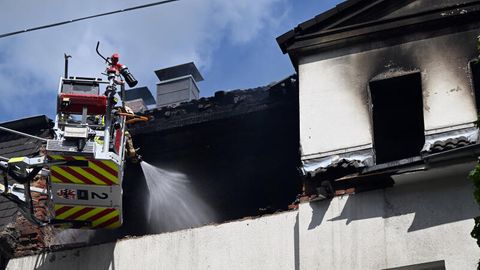 Feuerwehrleute löschen einen Brand in einem Dachstuhl.