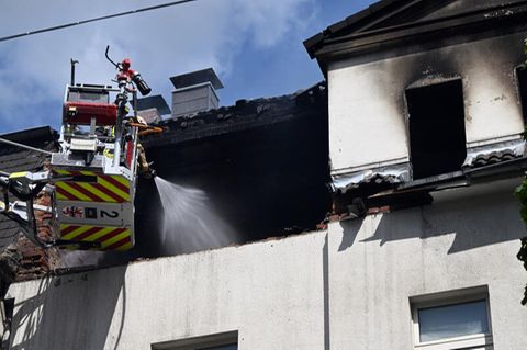 Feuerwehrleute löschen einen Brand in einem Dachstuhl.