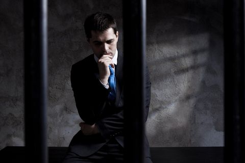 Ein Mann sitzt hinter Gittern
