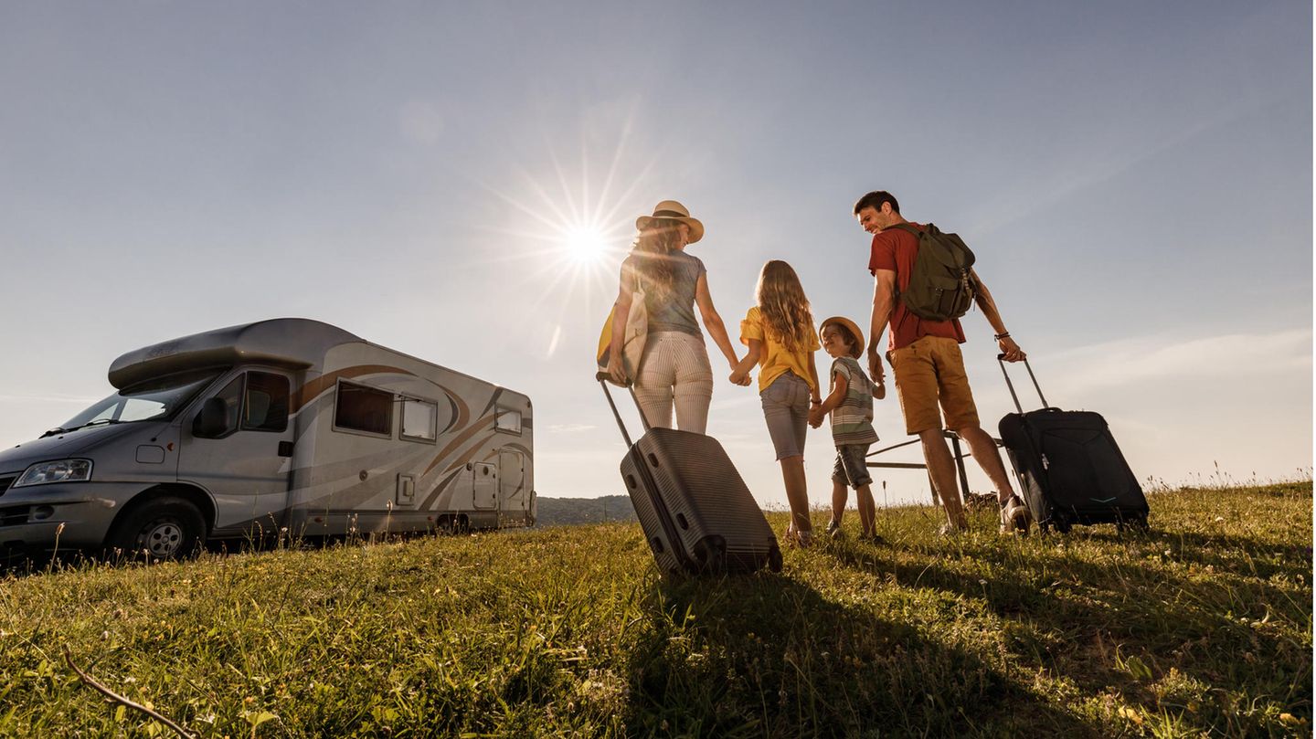 Checkliste für Wohnwagen und Wohnmobil: Camping auf Rädern Eine Familie geht zum Wohnwagen
