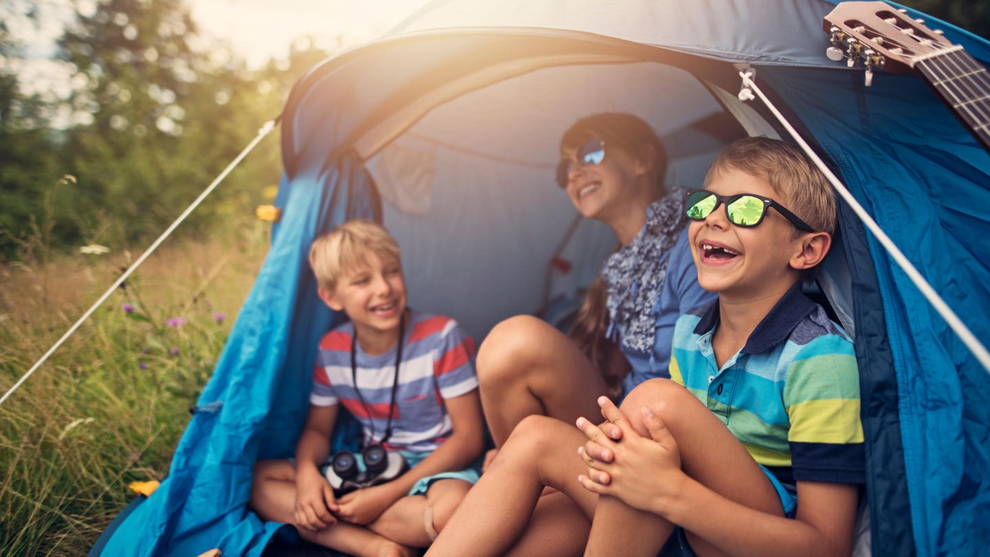 Drei Kinder sitzen in einem Zelt