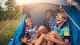 Drei Kinder sitzen in einem Zelt