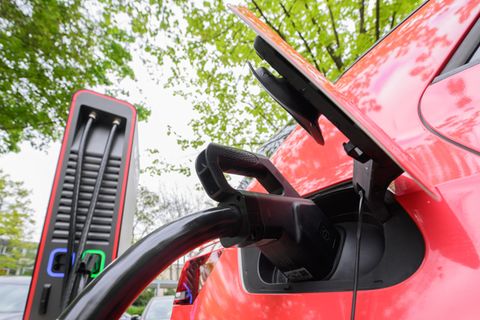 Ein Elektroauto steht an einer Ladesäule und ist mit einem Ladekabel verbunden