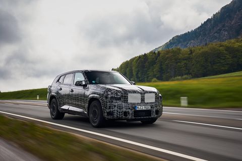 Ein BMW-Modell fährt in dunkler Tarnfolie über eine Straße