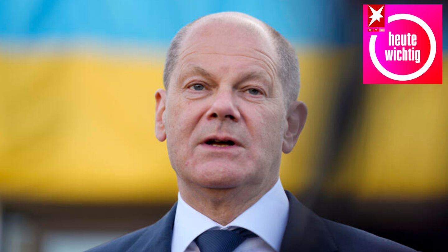 Kanzler Olaf Scholz vor blau-gelbem Hintergrund