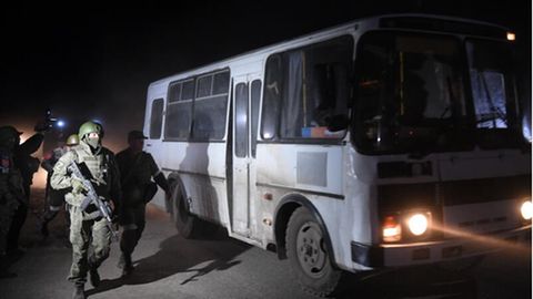Soldaten der sogenannten Volksrepublik Donezk begleiten einen Bus mit verwundeten ukrainischen Soldaten in Mariupol
