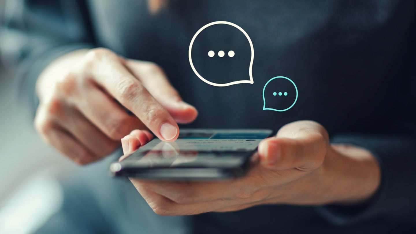 Eine Frau hält ein Smartphone in der Hand und chattet