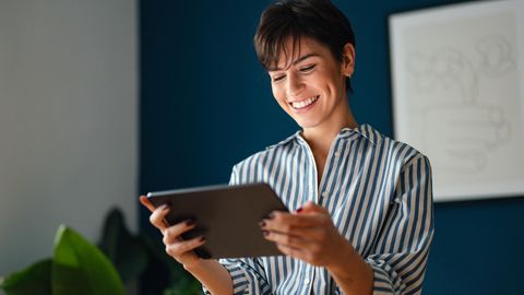 Eine Frau hält ein Tablet in den Händen