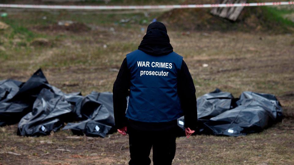Ein Ermittler trägt eine Weste mit der Aufschrift "War Crimes Prosecutor" ("Ankläger für Kriegsverbrechen", Archivfoto)