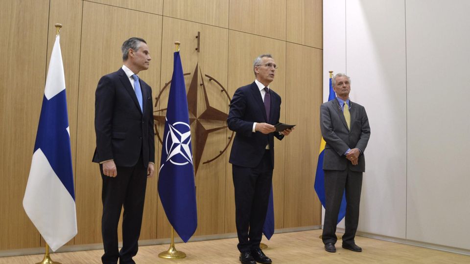 Klaus Korhonen (l) und Axel Wernhoff (r) überreichen Jens Stoltenberg die Anträge ihrer Länder auf die Nato-Mitgliedschaft