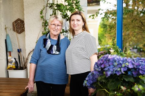 Olha (r) und ihre Gastgeberin Ulla stehen in Ullas Wohnung in Berlin-Friedenau auf dem Balkon