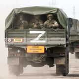 Uniformierte auf der Ladefläche eines Lastwagens, auf den ein weißes Z aufgemalt ist