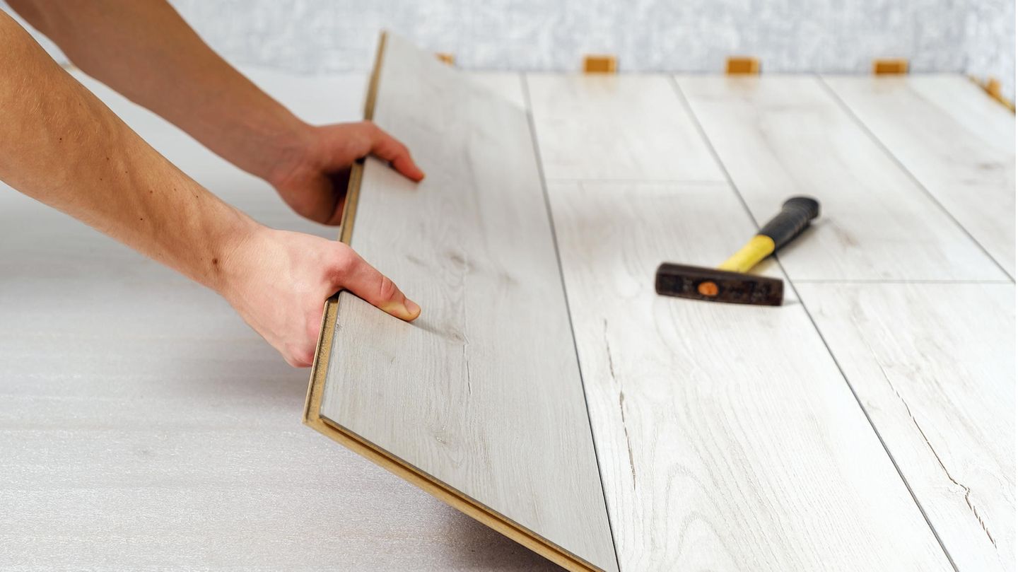 Hände verlegen Laminat oder Fertigparkett