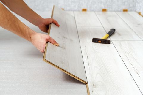Hände verlegen Laminat oder Fertigparkett