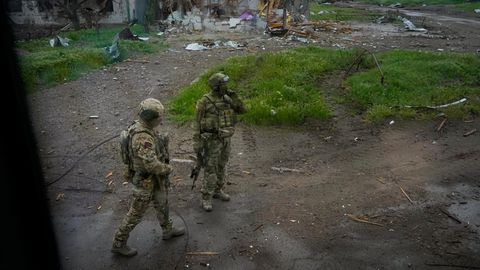 Russische Soldaten gehen während einer Evakuierung in Mariupol die Straße zum belagerten Stahlwerk Azovstal entlang