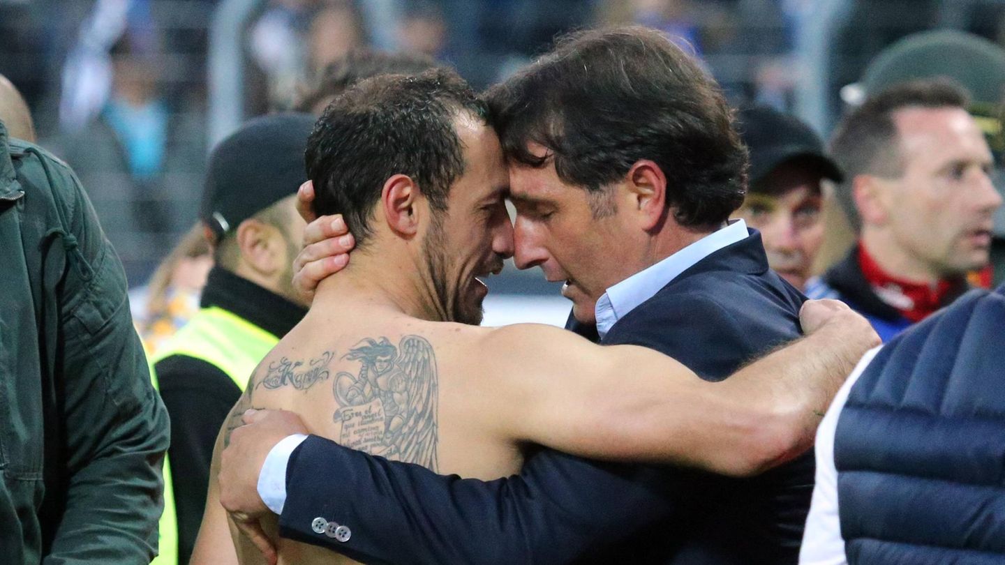 Das Rückspiel entwickelt sich zu einem echten Thriller. In der 78. Minute geht Karlsruhe in Führung und steht kurz vor dem großen Triumph — bis es in der Nachspielzeit einen Freistoß für die HSVer gibt, den ein gewisser Marcelo Diaz (im Bild mit Trainer Bruno Labbadia) tatsächlich erfolgreich verwandelt. In der Verlängerung rettet sich der HSV schließlich durch ein Tor von Nicolai Müller (zum 2:1) wieder vor dem Abstieg.