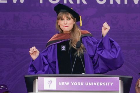Taylor Swift in Robe und mit Absolventen-Hut vor einem Rednerpult