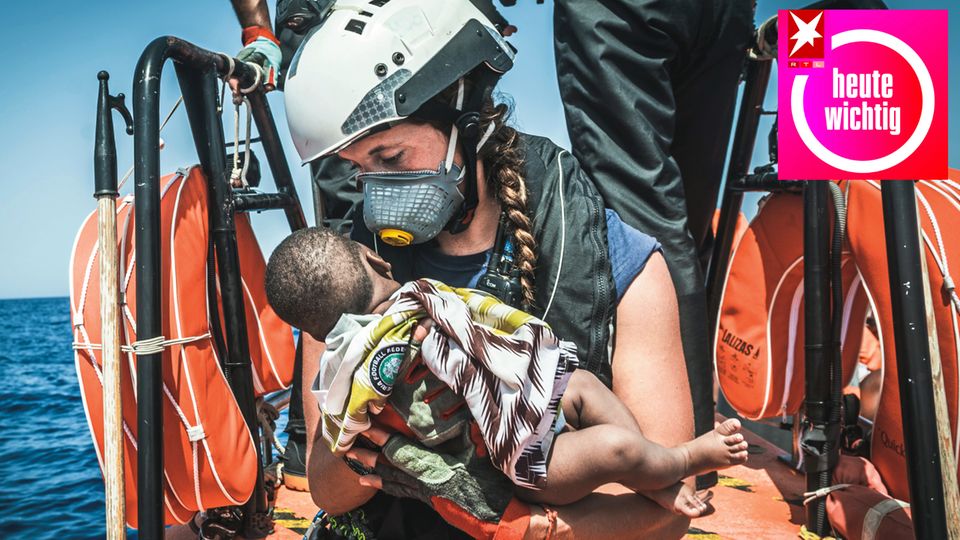 Helferin eines Teams des rettungsschiffes "Ocean Viking" hält ein Kind in den Armen