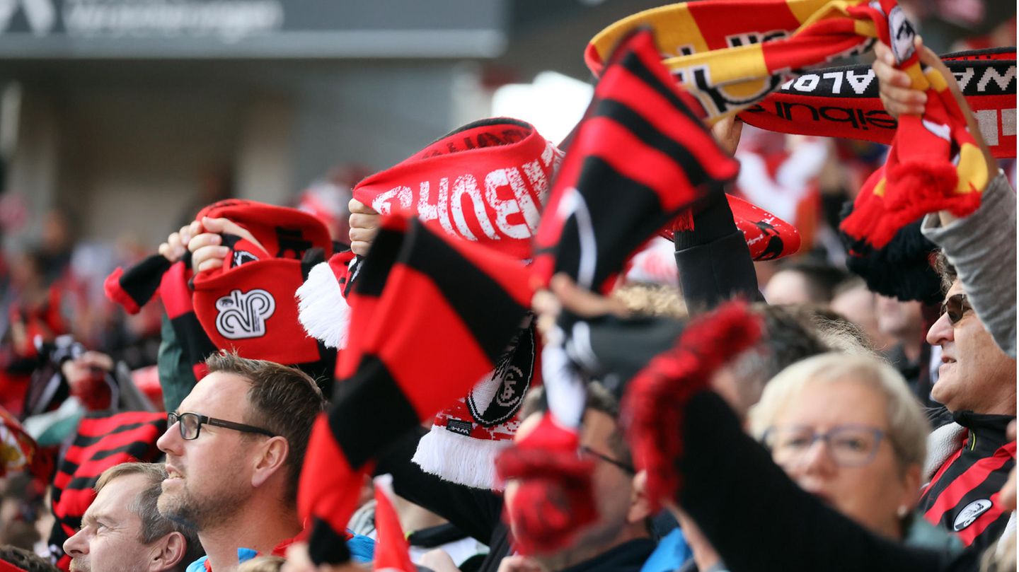 Fans des SC Freiburg schwenken Schals im neuen Europapark-Stadion