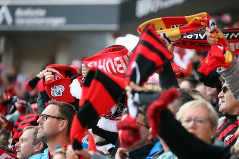 Fans des SC Freiburg schwenken Schals im neuen Europapark-Stadion
