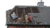 Menschen inspizieren den Schaden eines Daches