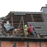 Menschen inspizieren den Schaden eines Daches