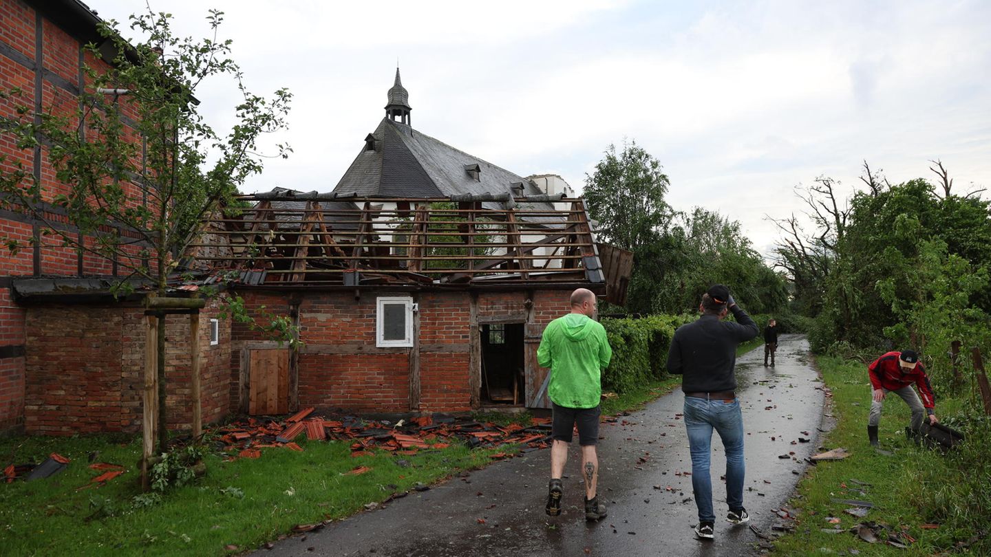 Menschen stehen vor einem beschädigten Haus