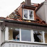 Eine Anwohnerin schaut aus einem der zerbrochenen Fenster ihrer Wohnung