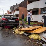 Anwohner fegen die Trümmer zusammen