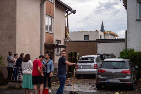 Bewohner eines Hauses stehen an der Straße