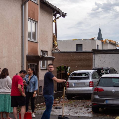 Bewohner eines Hauses stehen an der Straße