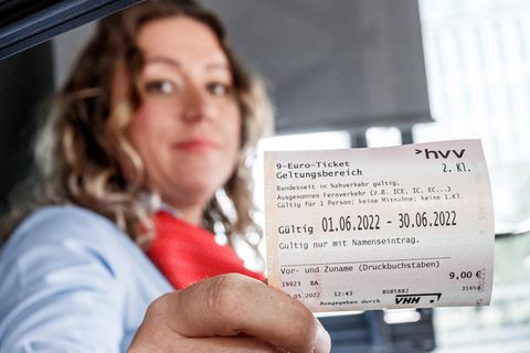 Ein Busfahrerin hält in Hamburg das 9-Euro-Ticket in der Hand