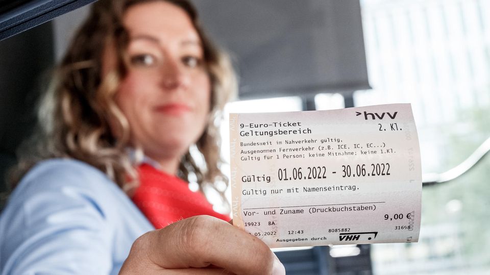 Ein Busfahrerin hält in Hamburg das 9-Euro-Ticket in der Hand