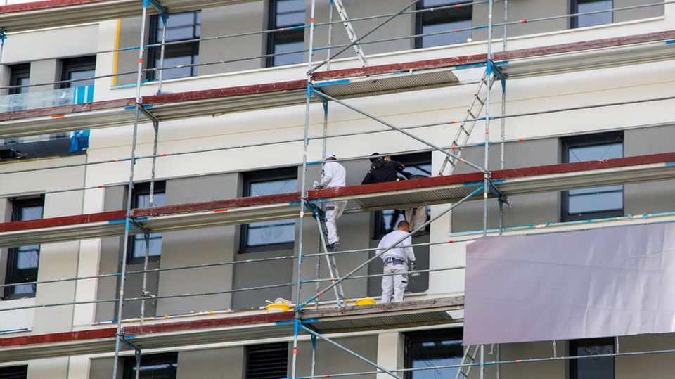 Maler streichen die Fassade eines neuen Gebäudes.