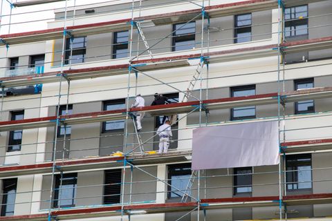Maler streichen die Fassade eines neuen Gebäudes.