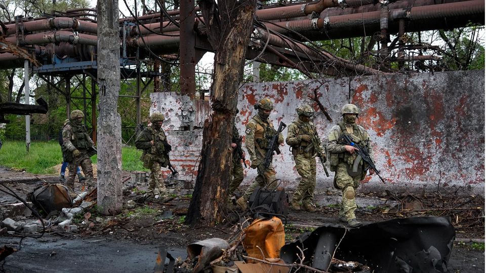 Russische Soldaten gehen durch einen zerstörten Bereich des Iljitsch Eisen- und Stahlwerks Mariupol