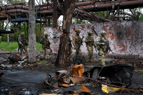 Russische Soldaten gehen durch einen zerstörten Bereich des Iljitsch Eisen- und Stahlwerks Mariupol