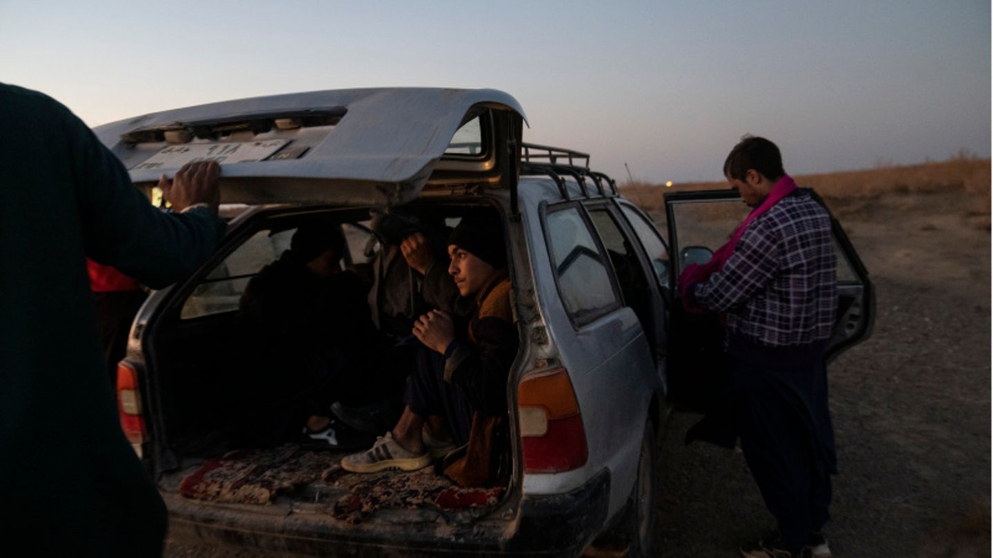 Afghanische Migranten steigen auf dem Weg in den Iran in ein Auto