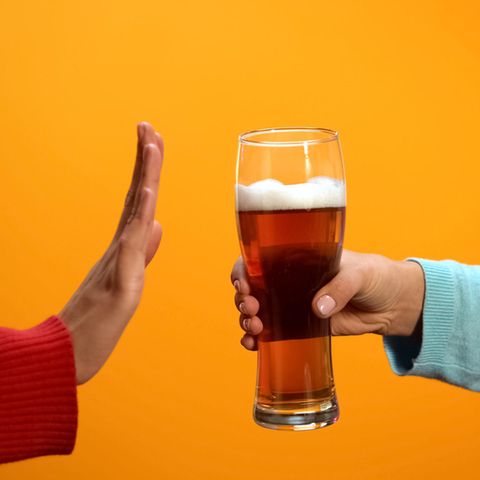 Eine Hand lehnt ein Glas Bier ab