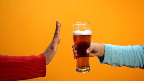 Eine Hand lehnt ein Glas Bier ab