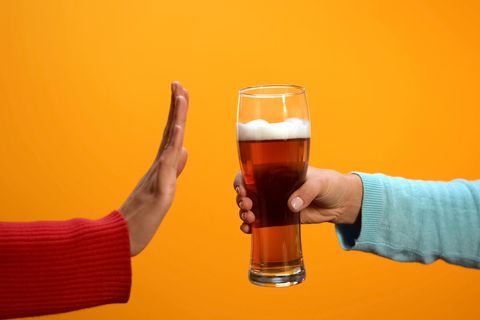 Eine Hand lehnt ein Glas Bier ab