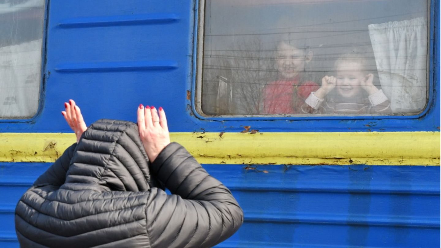 Eine Ukrainerin unterhält durch ein Waggonfenster des Evakuierungszuges am Bahnhof Kramatorsk Kinder