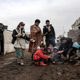 Migranten aus Syrien versammeln sich im Libanon um ein kleines Feuer, um sich zu wärmen. 