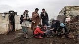 Migranten aus Syrien versammeln sich im Libanon um ein kleines Feuer, um sich zu wärmen. 