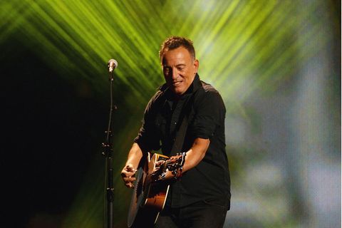 Bruce Springsteen steht bei einem Konzert mit Gitarre auf der Bühne